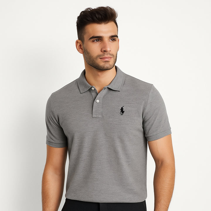 Man wearing a gray polo shirt with a brand logo on a white background