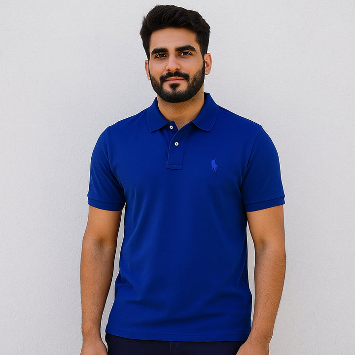 Man wearing a blue polo shirt against a plain background